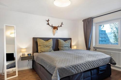 a bedroom with a bed with a deer head on the wall at Panoramablick und Ruhe in Titisee-Neustadt