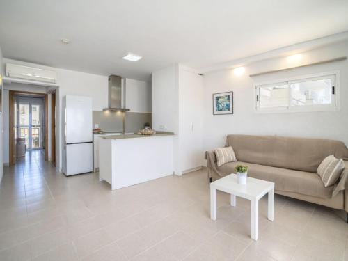 a living room and kitchen with a couch and a table at Apartment Xisca by Interhome in Port d'Alcudia