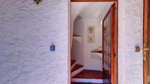 a hallway with a white wall and a stairway at Monolocale Porto Sole N 4 in Baja Sardinia