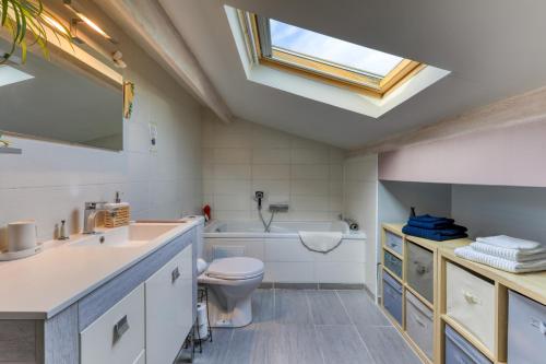 a bathroom with a sink toilet and a skylight at Villa Angelo - Lavande in Saint-Thibéry