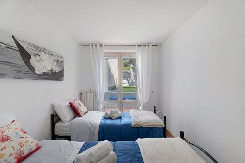 a bedroom with two beds and a window at La Perla House in Anacapri