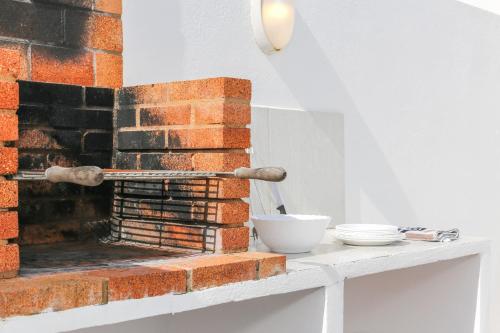 a brick fireplace on a white table with bowls on it at Villa Aday and Ixeia in Cala Blanca