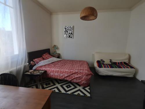 a small bedroom with a bed and a table at Maison Entre Les Ports in Les Sables-d'Olonne