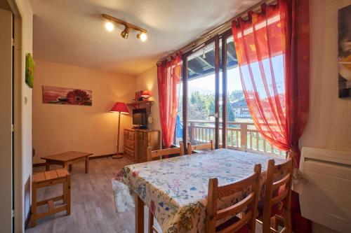 a room with a table and a balcony with a view at 2 Alpes - appartement 2-4 pers in Les Deux Alpes