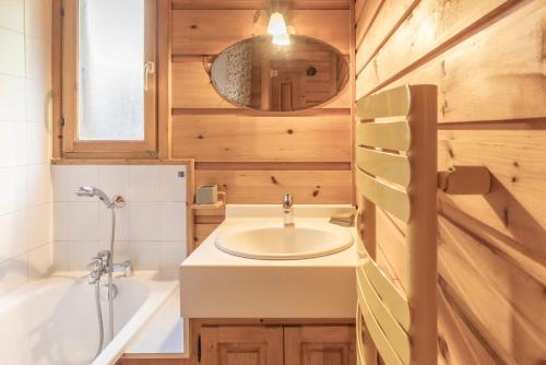 a bathroom with a sink and a tub and a mirror at Chalet cosy avec mezzanine in Verchaix