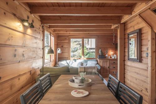 a dining room with a table in a log cabin at Chalet cosy avec mezzanine in Verchaix