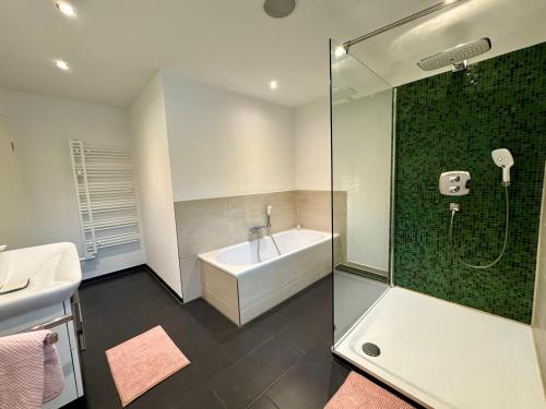 a bathroom with a shower and a tub and a sink at Citynah und Chic bei Hamburg in Norderstedt