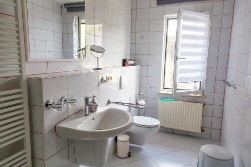 a white bathroom with a sink and a toilet at Ferienhaus Stahlberg in Potsdam