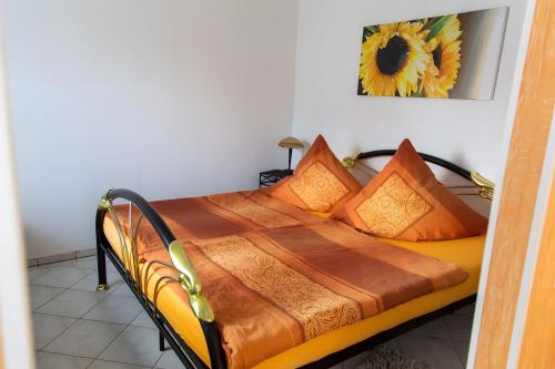 a bed with orange pillows on it in a room at Ferienhaus Stahlberg in Potsdam