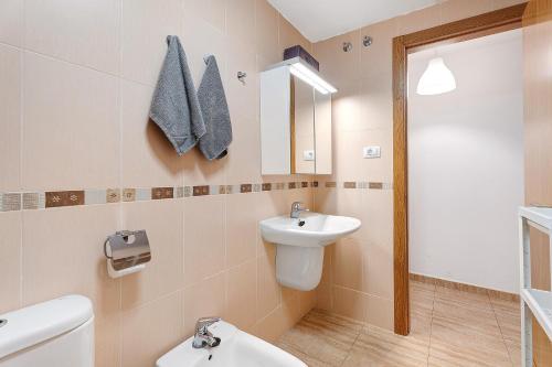 a bathroom with a sink and a toilet and a mirror at Cozy Tazacorte in Tazacorte