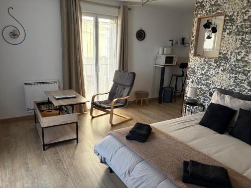 a bedroom with a bed and a chair and a table at Studio Sablé sur Sarthe in Sablé-sur-Sarthe