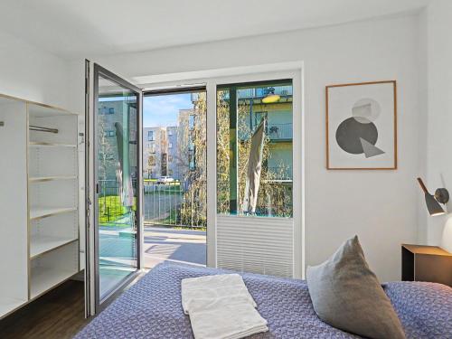 a bedroom with a bed and a sliding glass door at Apartment Seeflair by Interhome in Lembruch