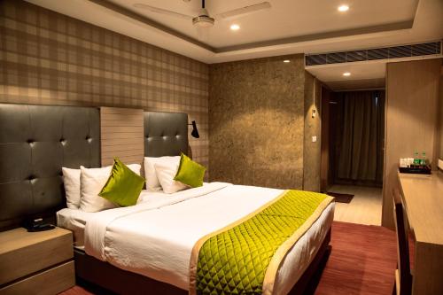 a bedroom with a large bed with green pillows at Banyan Palace in Chennai