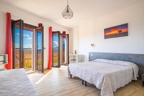 a bedroom with two beds and sliding glass doors at Affittacamere Da Riccardo in Jerzu