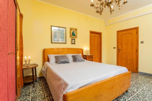 a bedroom with a bed and a table and a chandelier at Le Logge - Bronte in Bronte