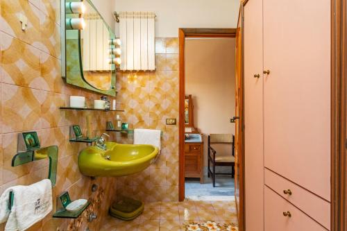 a bathroom with a yellow sink and a mirror at Le Logge - Bronte in Bronte
