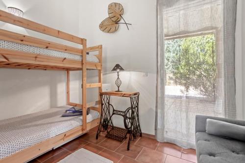 a bedroom with a bunk bed and a desk and a window at Gîte Les Tarentes avec piscine in Cotignac
