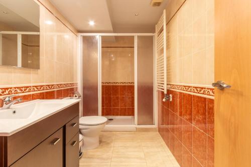 a bathroom with a toilet and a sink and a shower at Planta Baixa in Platja d'Aro
