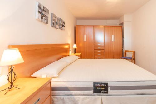 a bedroom with a bed and a desk with a lamp at Planta Baixa in Platja d'Aro
