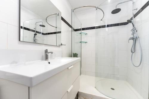 a white bathroom with a sink and a shower at Sea Front Beach House Micaela I in Marbella
