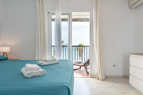 a bedroom with a blue bed with towels on it at Sea Front Beach House Micaela I in Marbella