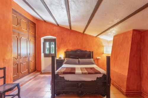 a bedroom with a bed with an orange wall at Can Marc in Dosríus