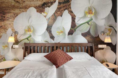 a bedroom with white flowers on the wall at Landhaus Trautwein in Vogtsburg