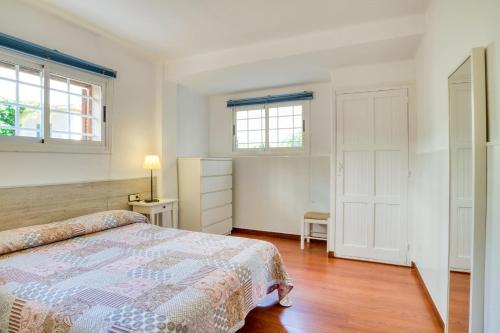 a bedroom with a bed and two windows at Nice apartment with terrace in Lloret de Mar