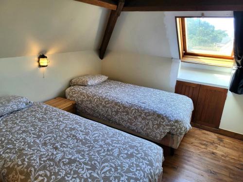 a small room with two beds and a window at Maison De Bord De Mer Alizée in Saint-Germain-sur-Ay