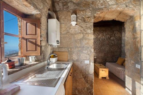 a kitchen with a sink and a stone wall at Eco Holidays House Races in Fasnia