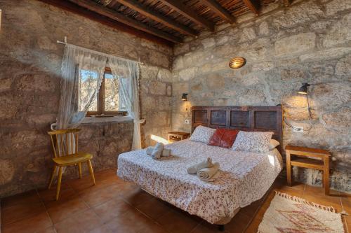 a bedroom with a bed and a stone wall at Eco Holidays House Races in Fasnia
