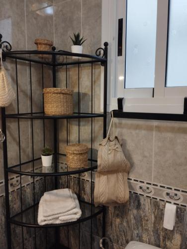 a bathroom with a shelf with towels and a toilet at Sweetcasitaarinagaplaya in Arinaga