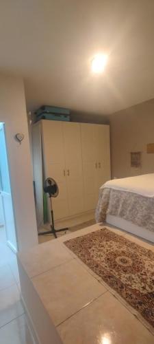 a bedroom with a bed and white cabinets and a rug at Sweetcasitaarinagaplaya in Arinaga