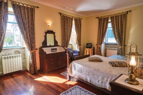 a bedroom with a bed and a dresser and a mirror at Casa do Mogadouro in Mesquitela