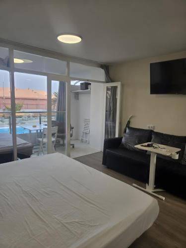 a bedroom with a bed and a living room with a couch at Apartamento Yumbo Roque Nublo in San Bartolomé