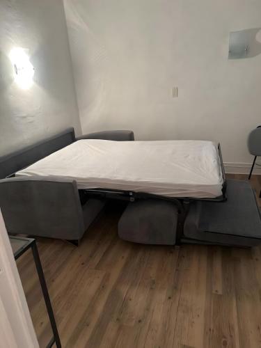 a small bed in a room with a wooden floor at Studio 2 personnes in La Bourboule