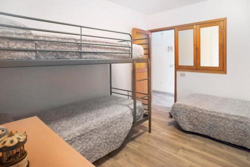 a room with two bunk beds and a table at El Faro Sardina in Sardina