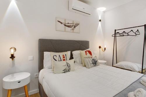 a white bedroom with a bed and a sink at O Marinheiro 15A in Caniçal
