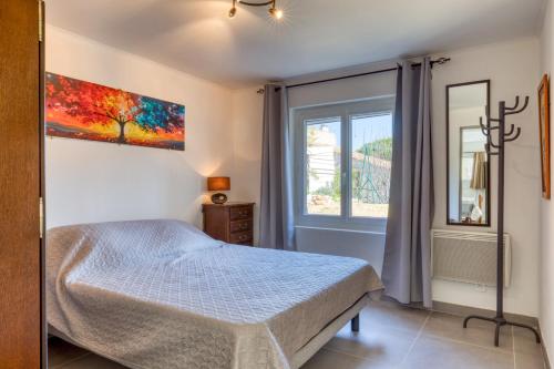 a bedroom with a bed and a window at Charmante location vacances in Montagnac
