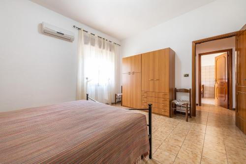 a bedroom with a bed and a dresser and a window at Casa Vacanze Teulada in Teulada