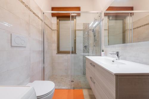 a bathroom with a shower and a toilet and a sink at Casa Vacanze Teulada in Teulada