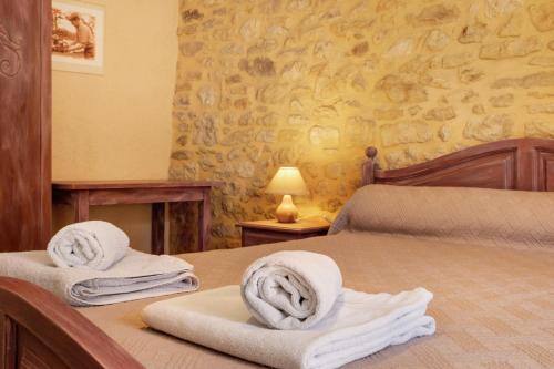 a bedroom with two beds with towels on them at La Ferme de la Croix d'Allon in Sarlat-la-Canéda