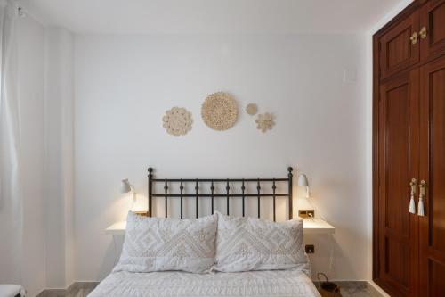 a bedroom with a bed with white sheets and two lamps at Duplex a 9 min De Bajo de Guia in Sanlúcar de Barrameda
