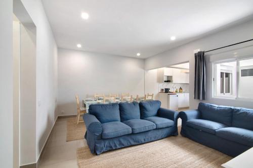 a living room with blue couches and a table at Skipper House in Loulé