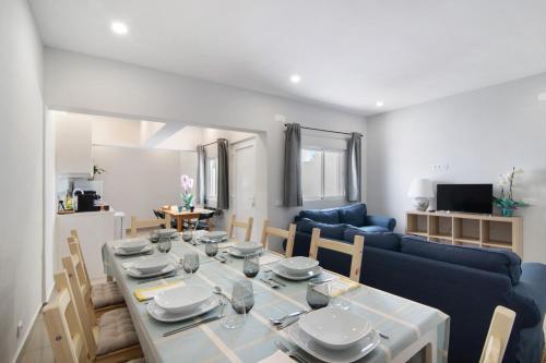 a living room with a table and a blue couch at Skipper House in Loulé