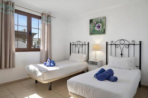 two beds with blue pillows in a bedroom at Casa Elian in Lanzarote