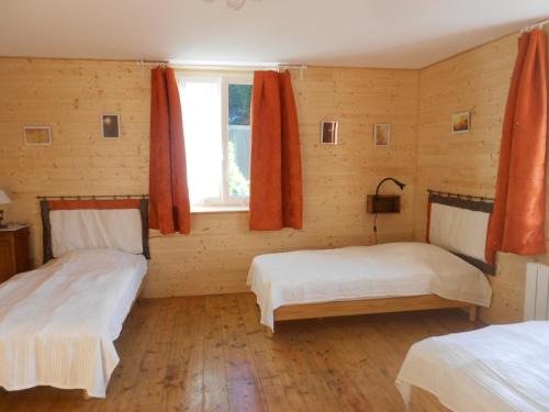 a bedroom with two beds and a window at Gîte Les Chamois 15 Personnes in Les Rousses