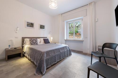 ein weißes Schlafzimmer mit einem Bett und einem Fenster in der Unterkunft Cà Granda Brenzone in Brenzone sul Garda