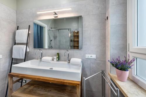 ein Badezimmer mit einem weißen Waschbecken und einem Spiegel in der Unterkunft Cà Granda Brenzone in Brenzone sul Garda