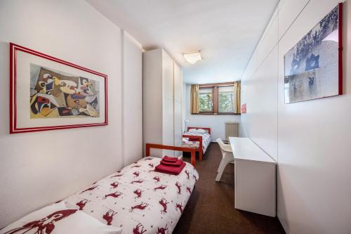 a small bedroom with a bed and a desk at Apt Vista sulla Vallata in Mazzin
